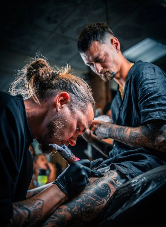 JB and a fellow artist tattooing side by side