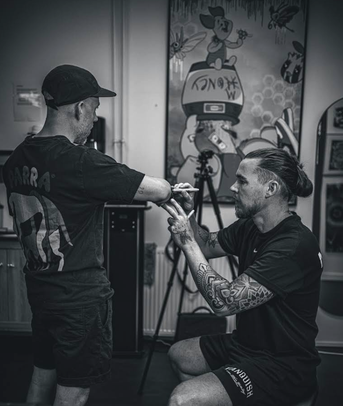 JB placing a stencil on a client's arm